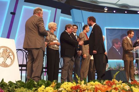 42.David T Jones (Chairman) accompanied by Gareth Davies (Committee Member) presenting the 1st prize in the Male Voice Choirs Competition at the 2012 International Musical Eisteddfod to Matthias Schmitt, conductor of the Delica Ton Choir from  Freigericht